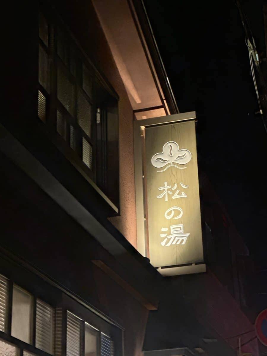 松のマークと「松の湯」の文字が入った木の看板