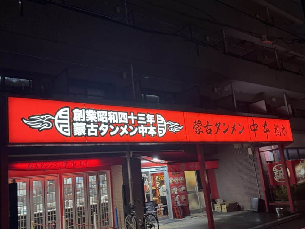 夜に赤く光る蒙古タンメン中本 橋本の看板と店の入口